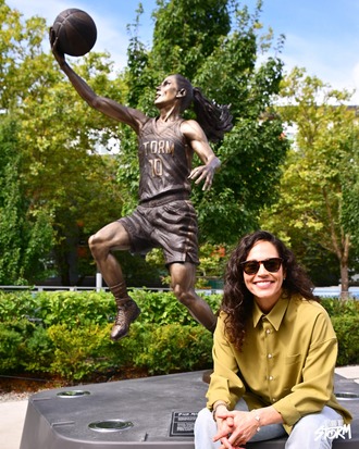 Sue Bird with her statue outside of Climate Pledge Arena