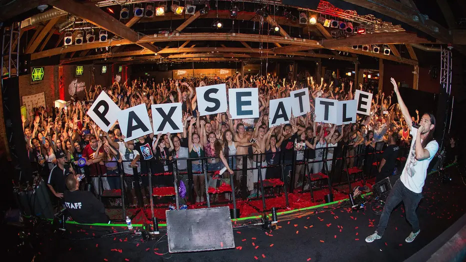 Fans holding signs that spell out "PAX SEATTLE"