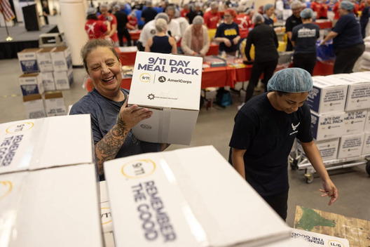 Volunteer stacks boxes of meals for shipment during the Seattle Meal Pack for 9/11 Day