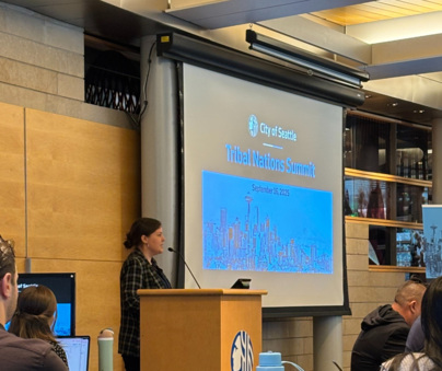 Francesca Murnan (Shawnee and Cherokee) standing in front of a screen that says Tribal Nations Summit