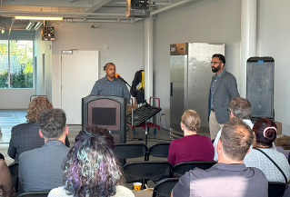 business owner speaking at a podium in front of a crowd of people