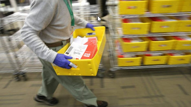 A King County Elections worker carries ballots to be processed