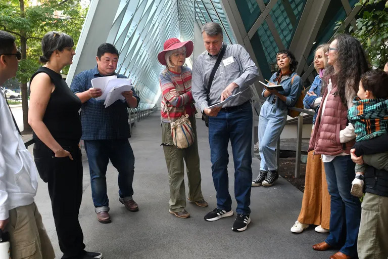 A group of people looking at papers during a tour
