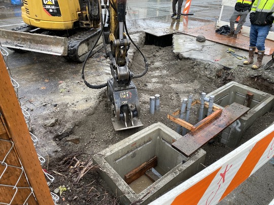 Crews fill the electrical trench before placing temporary pavement.