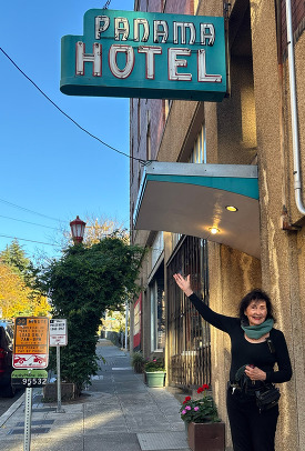 Jan Johnson standing under the sign of the Panama Hotel