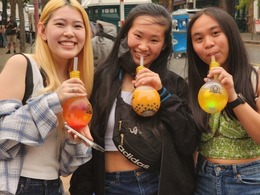 group of three girls drinking boba from lightbulb shaped cups