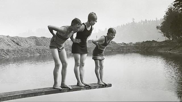 An archival black and white photo of people swimming on Lake Washington in the 1930s