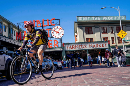 a man on a bike in front of pike place market