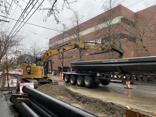 Crews dig a trench for the water main under Eastlake Ave E.