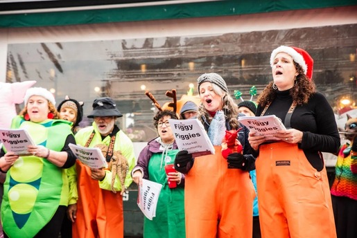 People caroling at the Great Figgy Pudding Caroling Competition at Pike Place Market