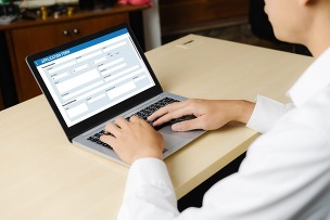 a person using a laptop of fill out an application form