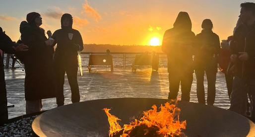 People gathered around a firepit on Pier 62