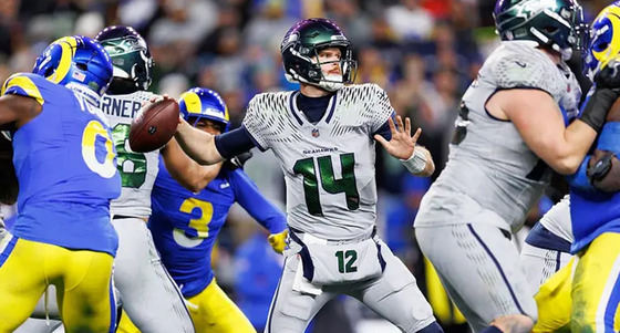 Seahawks quarterback Sam Darnold getting ready to throw a pass in a football game against the LA Rams