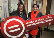 Two women holding a large red 2-D key that says 'Urban League Future Homeowner'