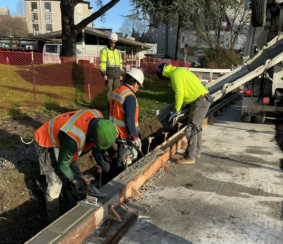 Crews pour concrete for new curbs.