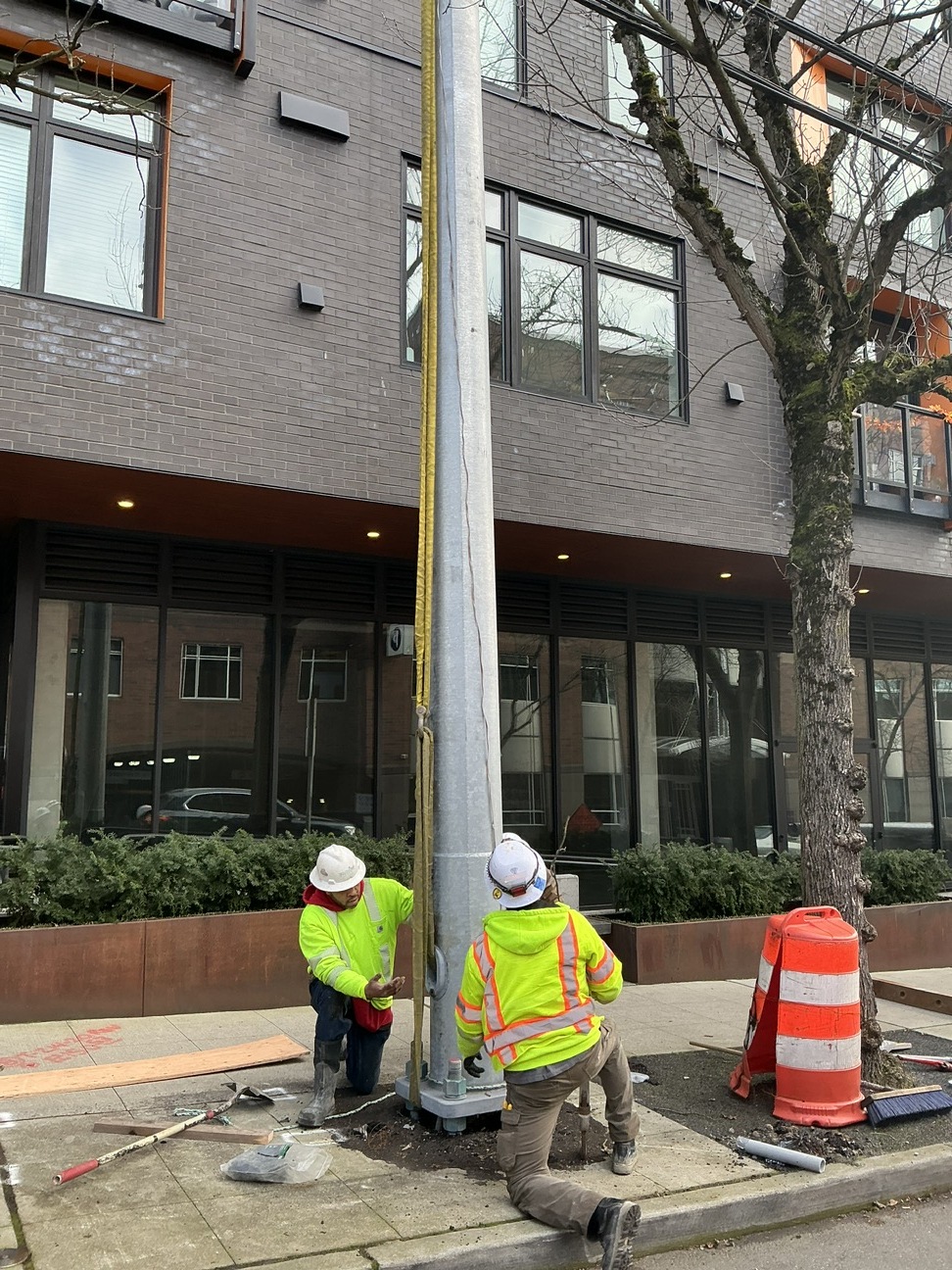 Crews installing overhead power poles.
