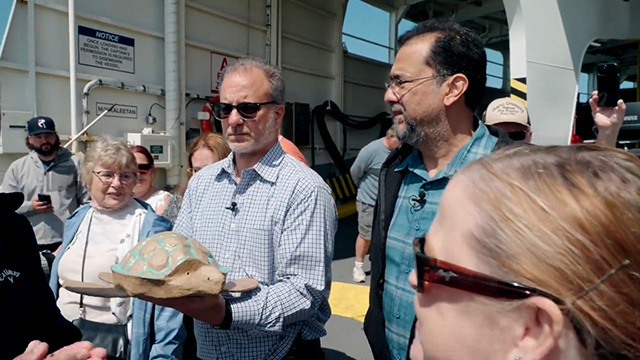 Family members hold the ashes of a loved one on a Washington State Ferry