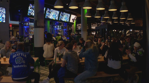 people at a bar cheering for the Seahawks