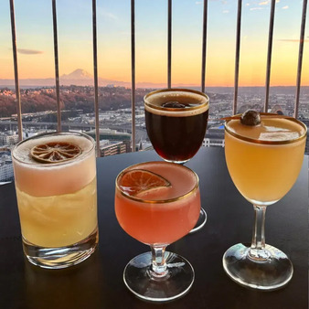 four drinks sitting on a table with Rainier in the background at sunset