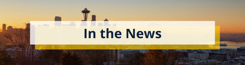 Seattle's skyline at dusk with the Space Needle. The sky is light orange and gray. The heading overlay says "In the News" in black bold font.