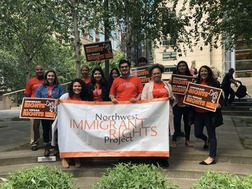 Group of People holding 'know your rights' signs and large 'Northwest Immigrant Rights Project" banner.