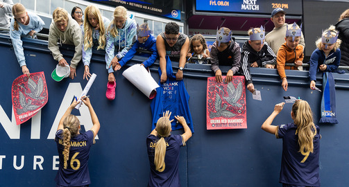 Seattle Reign FC player signing jerseys for little kids