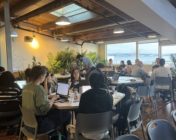 Participants working on their projects at the Community Innovation Hackathon at the AI House