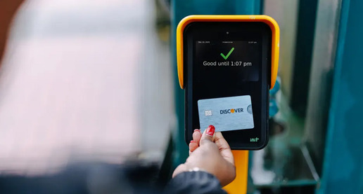 A person using a Discover credit card with ORCA's new contactless "Tap to Pay" feature 