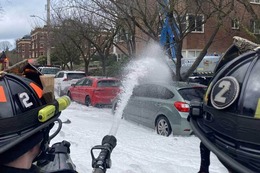 Two firefighters putting water on a fire