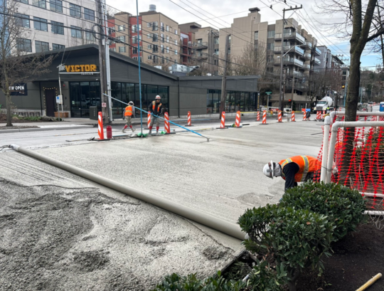 Crews smooth out new concrete near The Victor Tavern. 