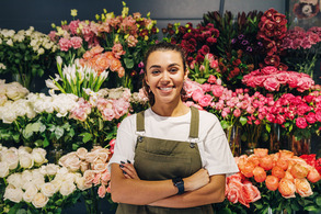 Florist wearing apron standing in front of flowers