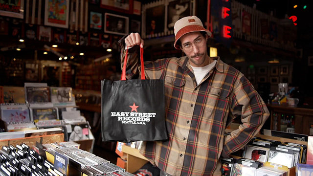 A customer holds up an Easy Street Records tote bag