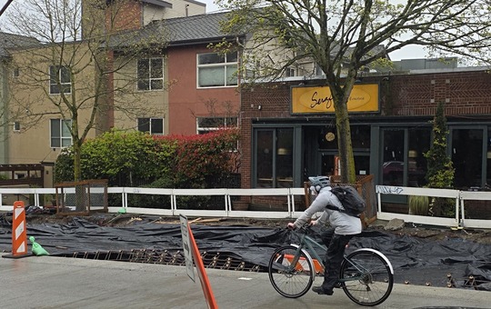 Undeterred by the rain, cyclists travel along Eastlake Ave E each day on sections of new, smoother road surfaces.  