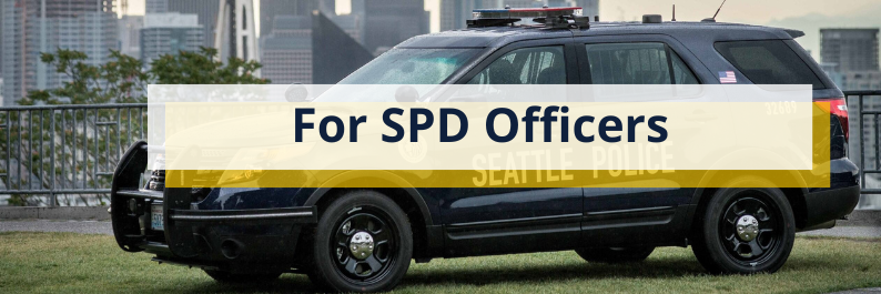 Photo of an SPD cruiser parked in the grass with a white and yellow box with text overlay that says "For SPD officers"