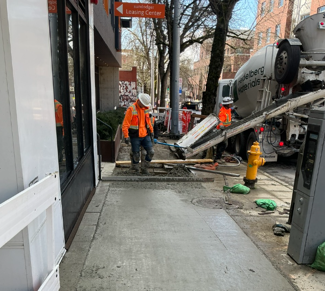 Crews pour new sidewalks near the Sundodger Apartments on Roosevelt Way NE. 