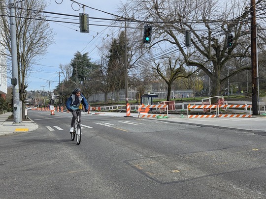 Bicyclist traveling beside the construction areas at Eastlake Ave E and E Louisa St. 
