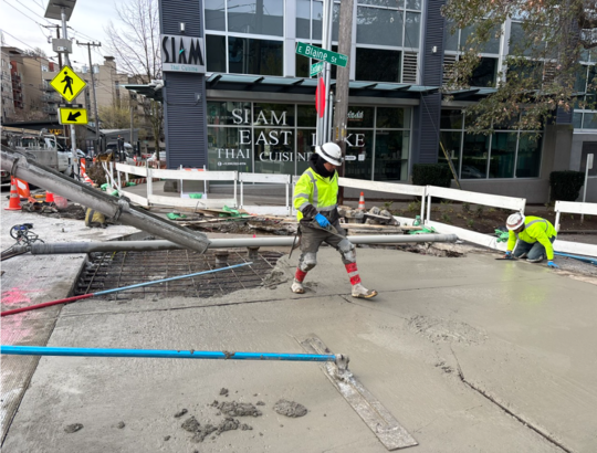 Crews pour new concrete at the intersection of Eastlake Ave E and E Blaine St. 
