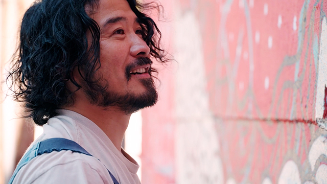 Shogo Ota paints a red mural.