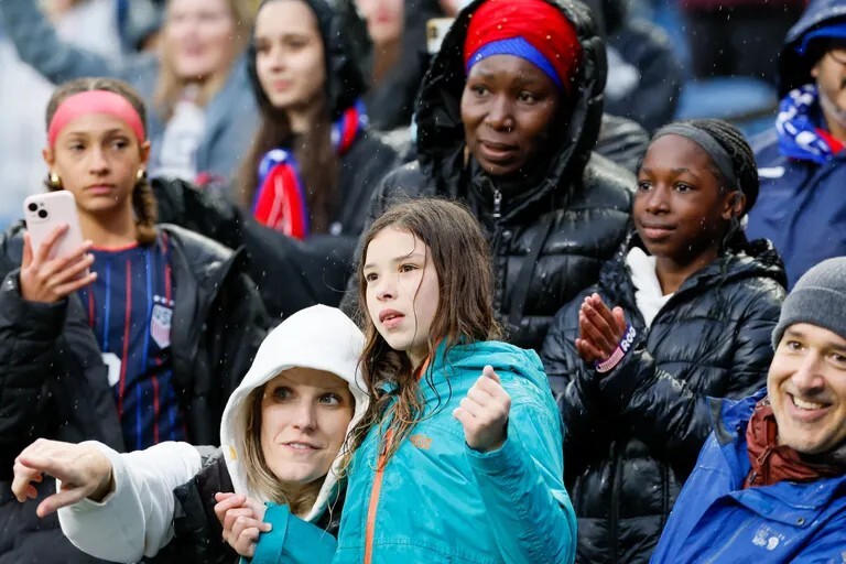 Fans at rainy women's soccer game