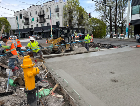 Crews smooth out new concrete on the east side of E Edgar St and Eastlake Ave E. 