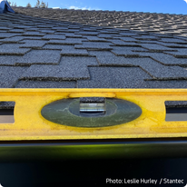 A level set on top of a gutter showing a small amount of slope. This type of photo is acceptable as evidence of gutter slope