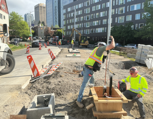 Crews install foundations and wires for a new RapidRide J Line bus stop in the University District.
