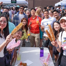 U District Fair attendees eating and smiling