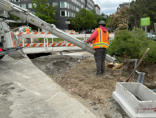 Crews pour concrete into circular molds for new poles supporting traffic signals and electrical wires.