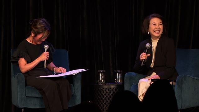 Mimi Gan and Lori Matsukawa share a laugh on stage.