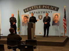 Detectives in suits standing at a podium