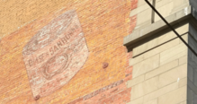 A faded painted advertisement on a brick wall