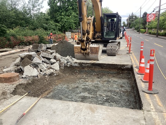 Picture of excavator removing old concrete panels in preparation for grading and pouring.