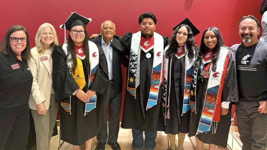 Ana Sanchez Leon and Daniel Pastor pose for a photo with friends and family on graduation day