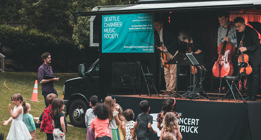 Kids enjoying music outside of the Seattle Chamber of Music's concert truck